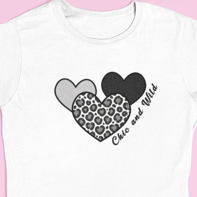 Close‑up of the three‑heart graphic—solid black, leopard print, and grey—with the text ‘Cute and Wild’ printed across all three hearts.
