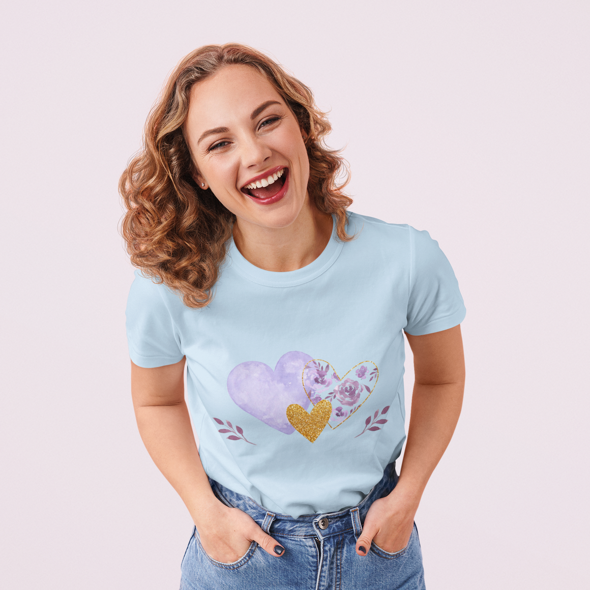 Model wearing the Light Blue tee featuring the lavender and gold floral heart motif.  
