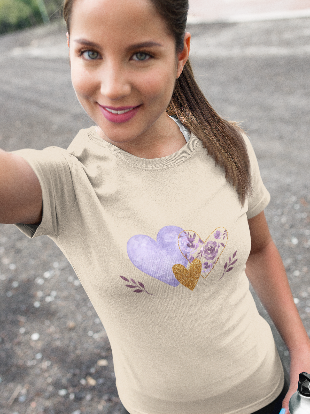 Model wearing the Sand tee featuring the lavender and gold floral heart motif. 