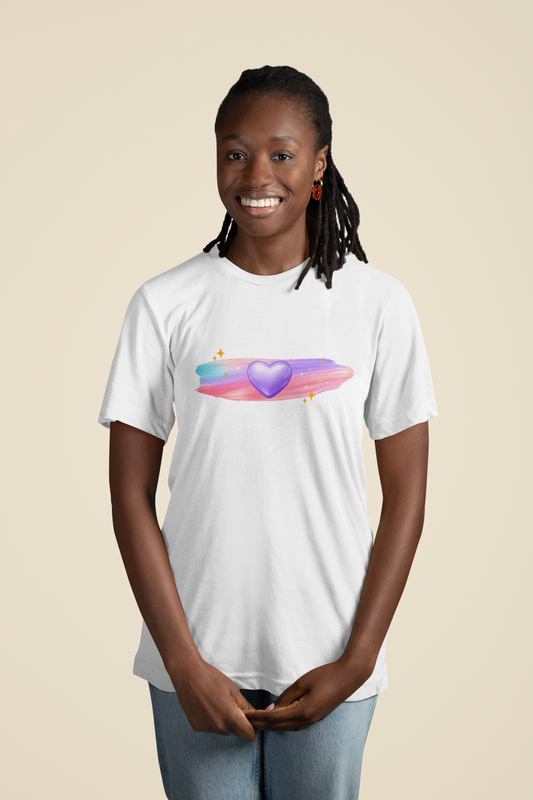 Woman wearing a white t‑shirt featuring a glowing purple heart with pastel brushstrokes and subtle sparkle accents.