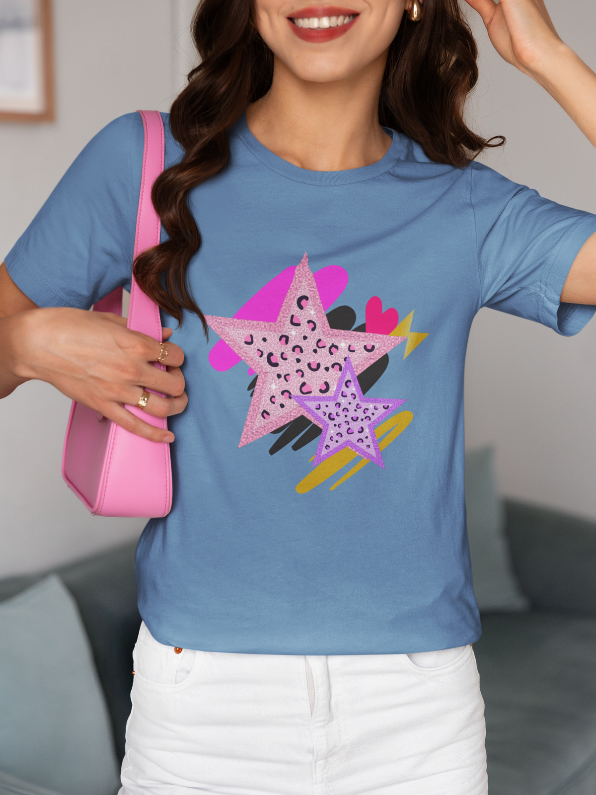Model wearing Blue Leopard Star Tee featuring pink and purple leopard‑print stars with gold and black brushstrokes.
