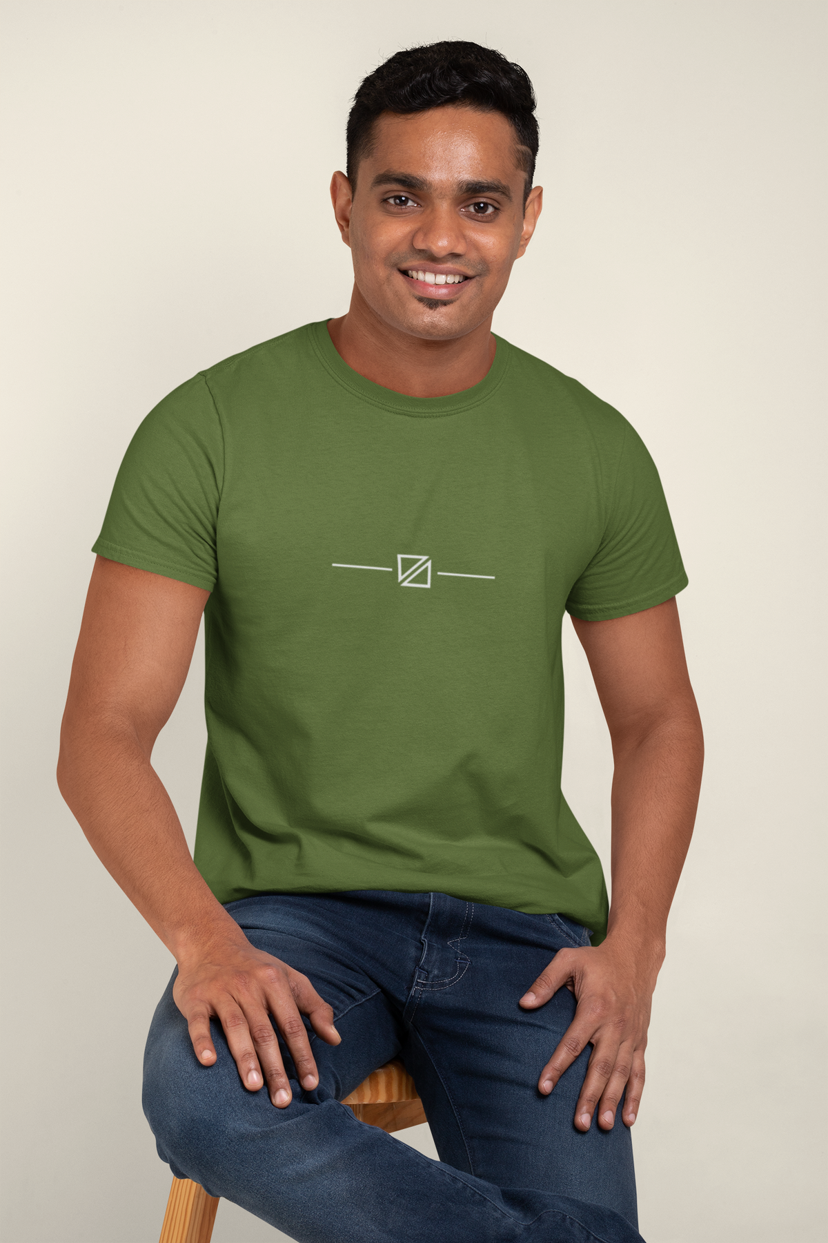 Model wearing the Minimal Geometric Crest Tee in Military Green featuring the centred linework crest motif.