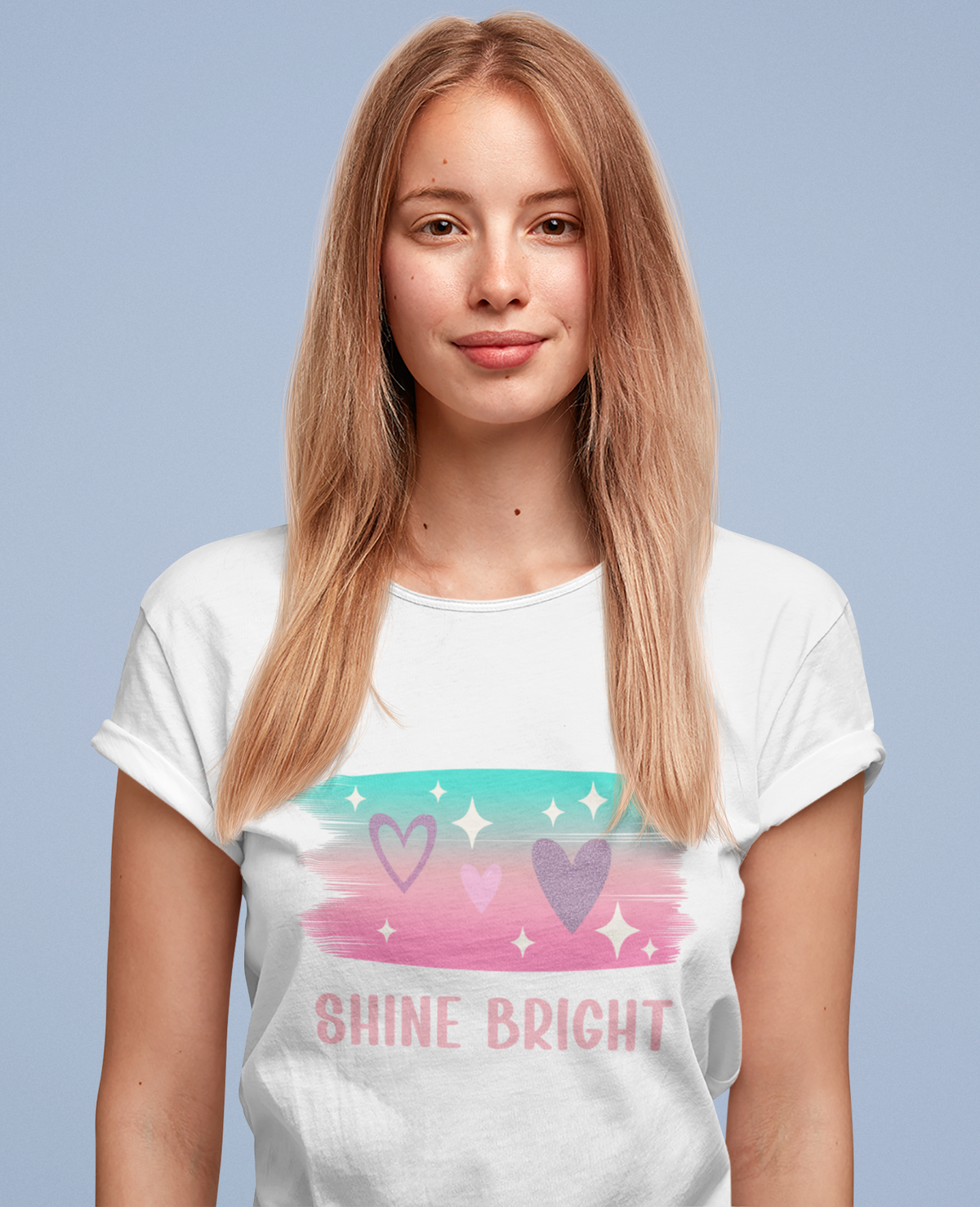 Model wearing the white Shine Bright Pastel Tee with soft stars, hearts, and brush‑stroke colours.
