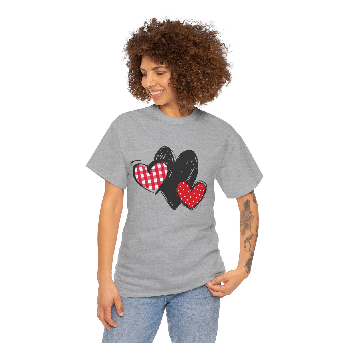 Grey T‑shirt with gingham, sketch, and polka dot triple‑heart artwork, worn by model,