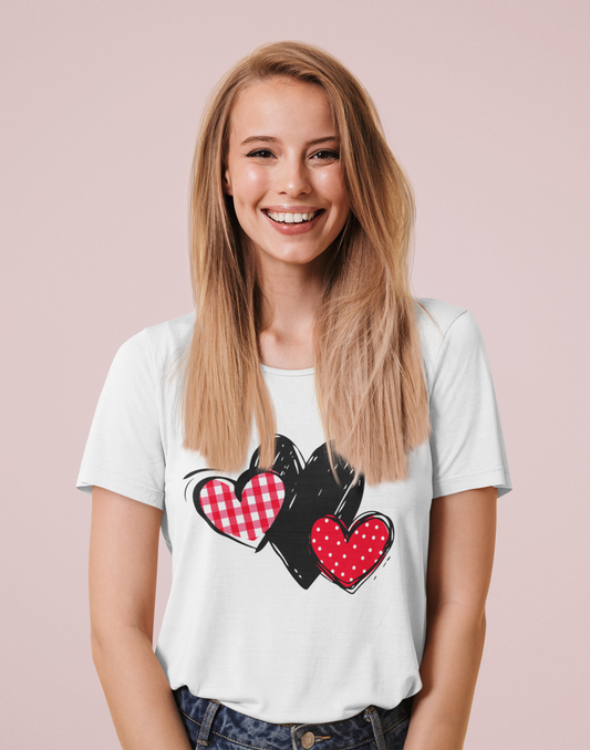 White T‑shirt with gingham, sketch, and polka dot triple‑heart motif, worn by model.